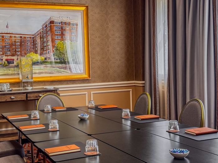 Black table by grey chairs under a large painting in Cedar Springs at Warwick Melrose Dallas