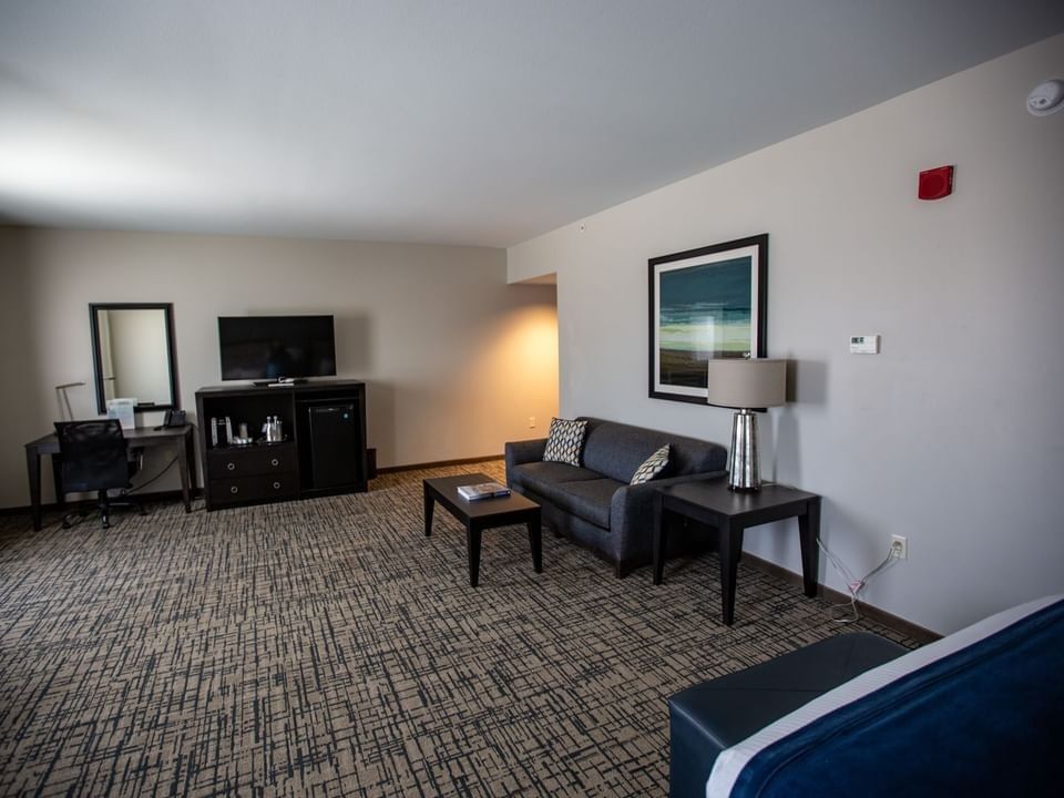 TV, side cupboard, and work desk facing the bed in the King Sofa Room at Shangri-La Resort and Golf Club