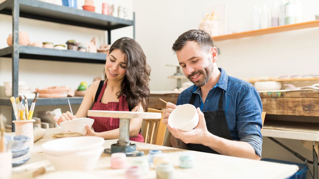 Couple having fun painting pottery