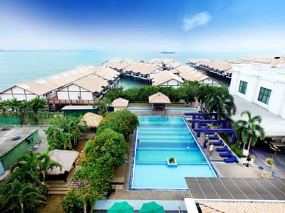 View of beachfront resort with pool and overwater chalets – Lexis Port Dickson