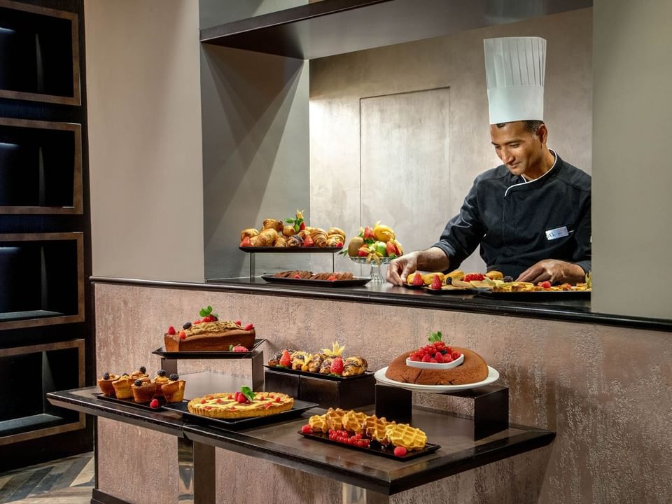 Chef arranging an elegant buffet spread in the breakfast area at The Style