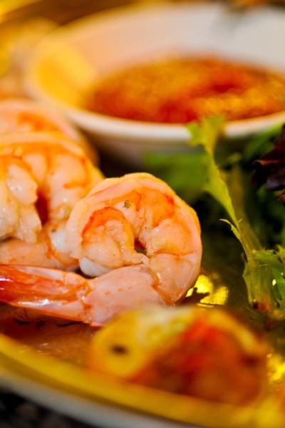 Close-up of cooked cocktail shrimp served with dipping sauce & greens served in Piccolo Arancio at Farmington Inn and Suites