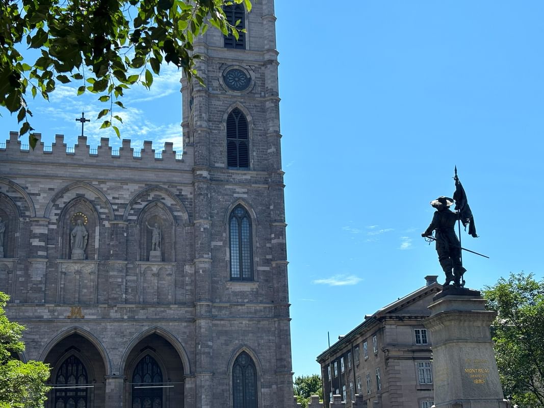 Statue et basilique en pierre sous un ciel bleu à Warwick Le Crystal Montreal