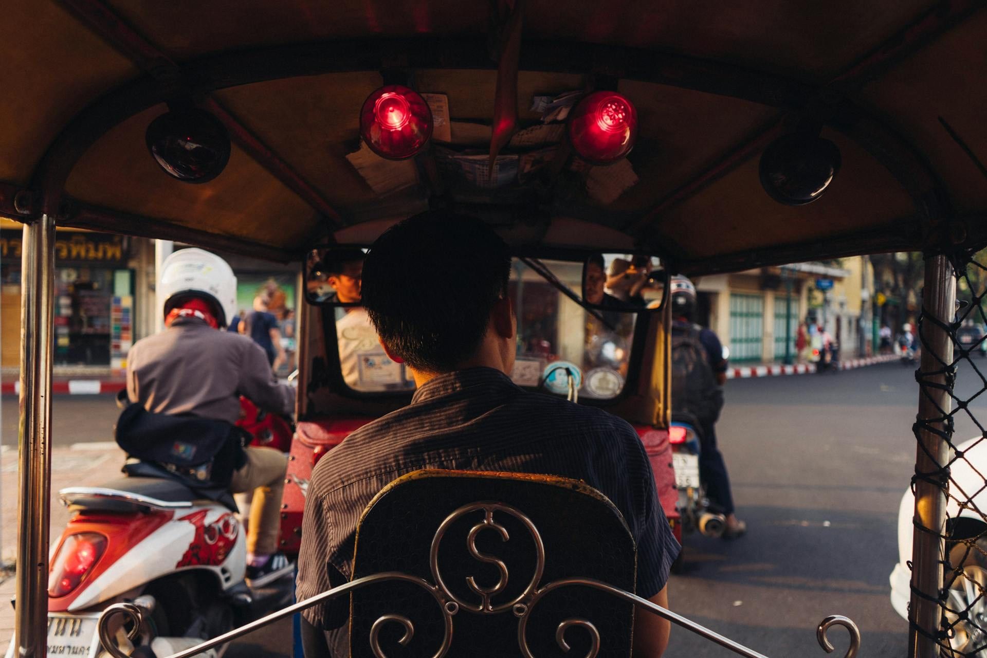 Passenger in a tuk-tuk by a street scene near Paradox Bangkok, one of the 4-star hotels in Sukhumvit, Bangkok