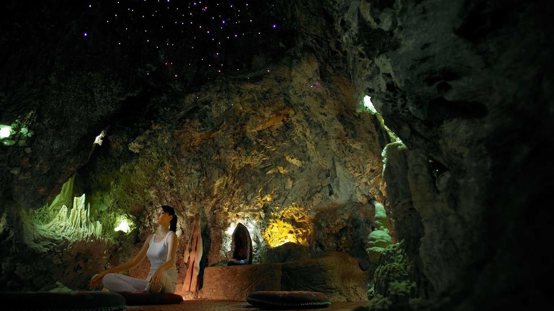Woman meditating inside a treatment cave near The Banjaran Hotsprings Retreat