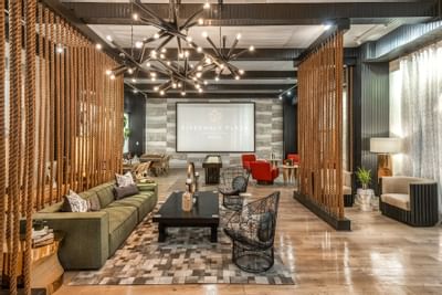 Lounge with rope dividers, stylish furniture, and large signage at The Riverwalk Plaza Hotel