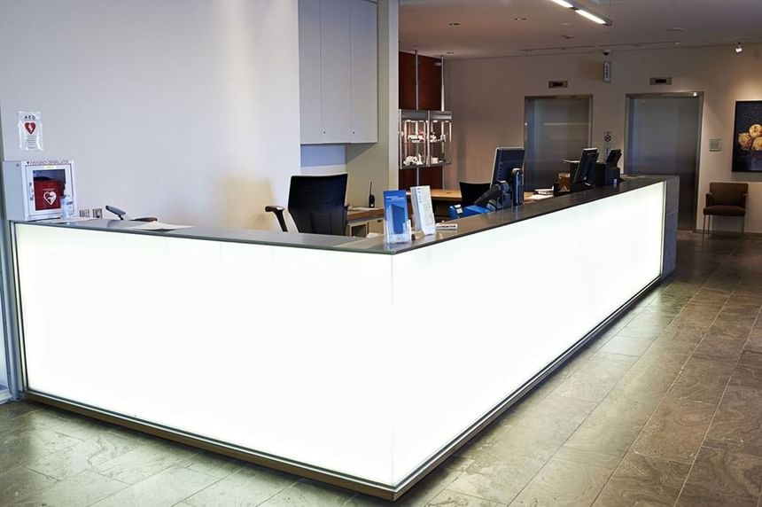 Main reception desk with a large modern counter with a white illuminated front at the Schulich School of Business.