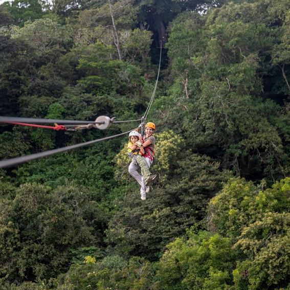 Couple ziplining through the forest near Buena Vista Del Rincon