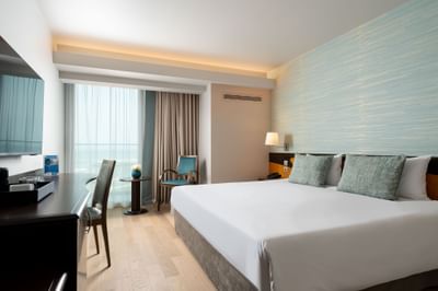 Room featuring a king-sized bed, a cozy seating area, and large windows with sheer curtains at Ana Hotels Europa Eforie Nord