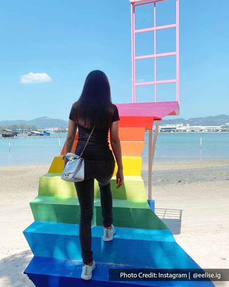 A woman was climbing a rainbow staircase at Pulau Jerejak - Lexis Suites Penang