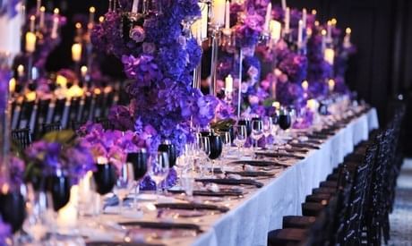Long banquet table set for event with floral centerpieces
