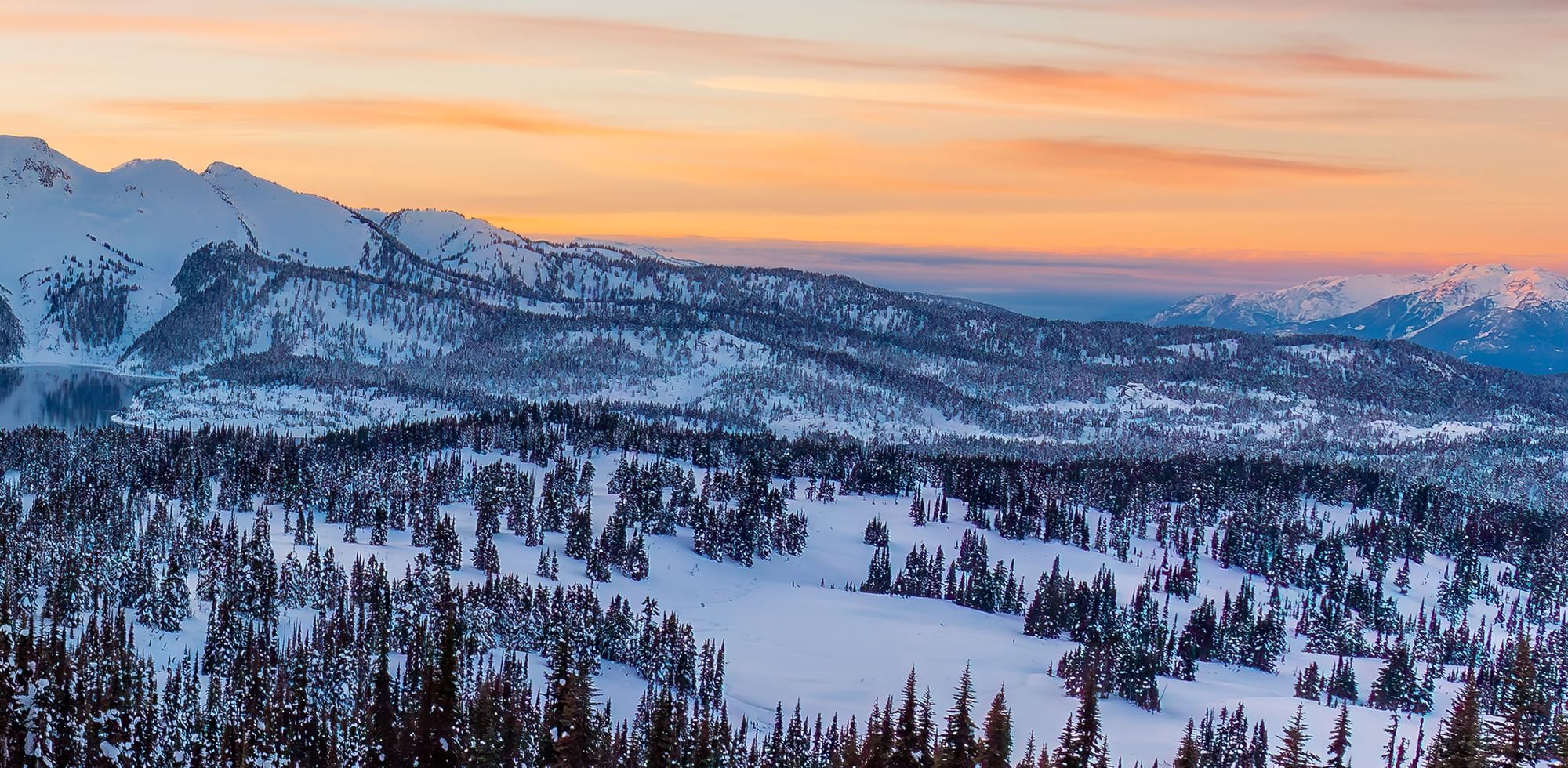 Aerial view of Whistler Mountain covered with snow at sunset near Listel Whistler, a Coast Hotel