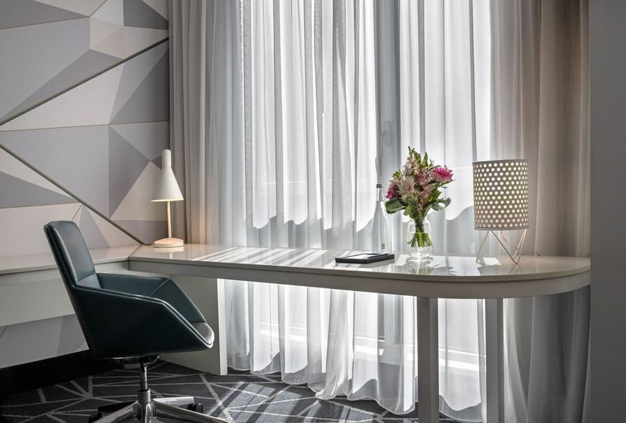 Table lamp and flower vase on the work desk with chair near window in Loft Suite at Warwick Le Crystal Montreal