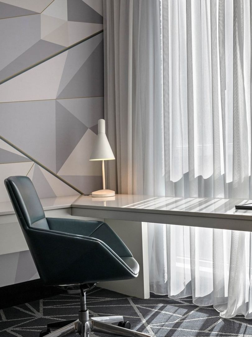 Bureau avec chaise et fleurs dans une suite Loft au Warwick Le Crystal – Montréal.