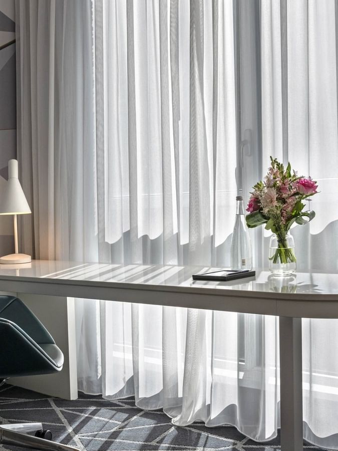 Table lamp and flower vase on the work desk with chair near window in Loft Suite 2 King Beds at Warwick Le Crystal Montreal