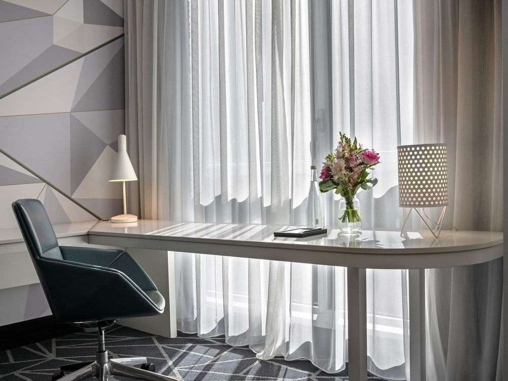 Bureau avec chaise et fleurs dans la suite Loft du Warwick Le Crystal – Montréal.