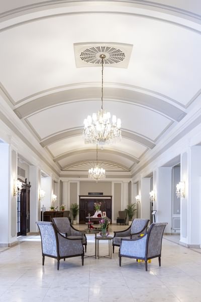 Armchairs by a coffee table under crystal chandeliers at Rodd Charlottetown Hotel