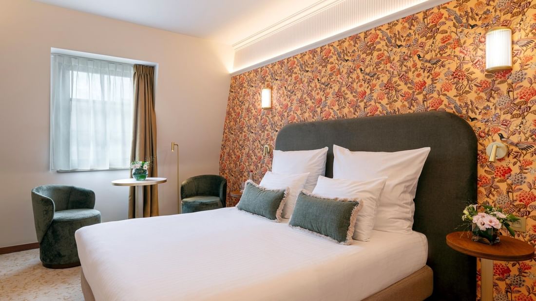 Classic Kamer met kingsize bed, bloemmotief behang en groene fauteuils bij Warwick Brussels Grand-Place in Brussel