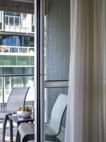 Balcony seating with chairs & a fruit bowl, seen through a glass door in Junior Balcony Suite at Warwick Le Crystal Montreal