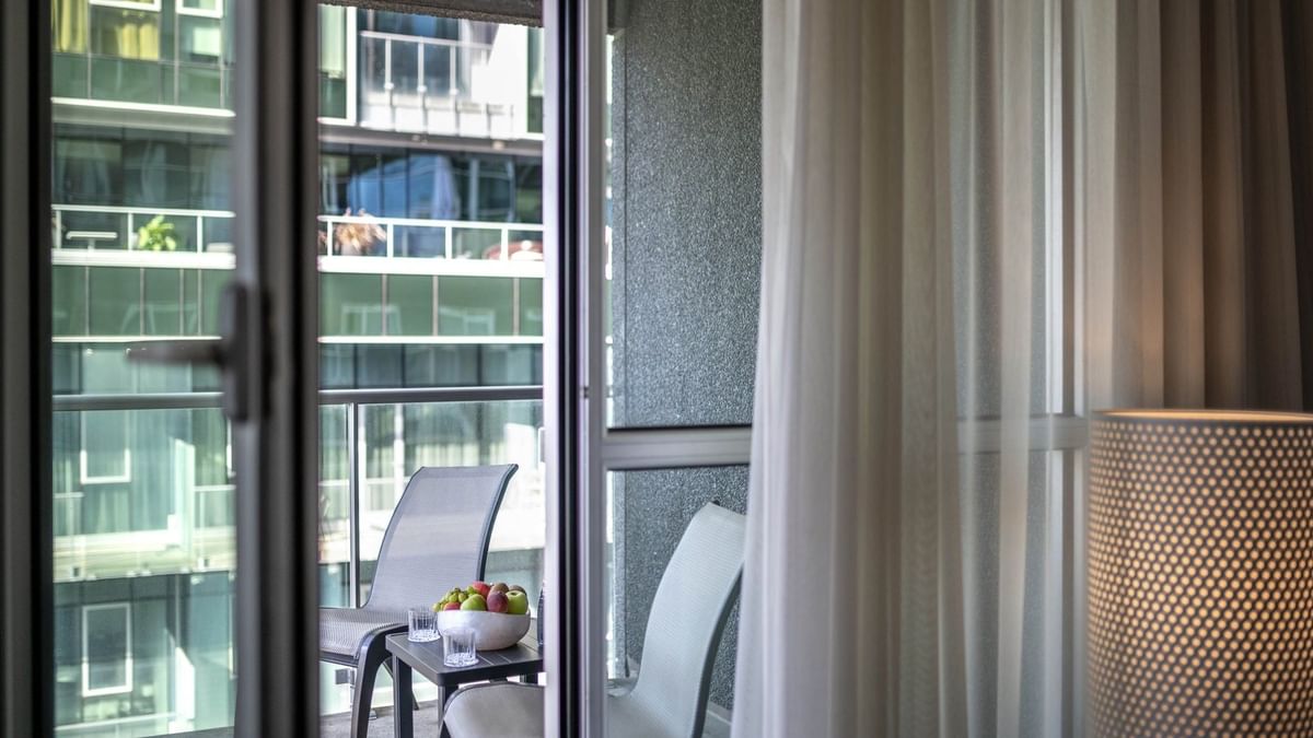 Balcon avec vue sur la ville et chaises au Warwick Le Crystal – Montréal.