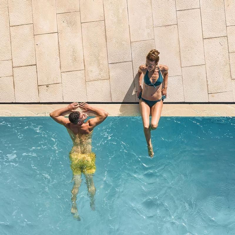 Couple enjoying the pool at Falkensteiner Hotels & Residences