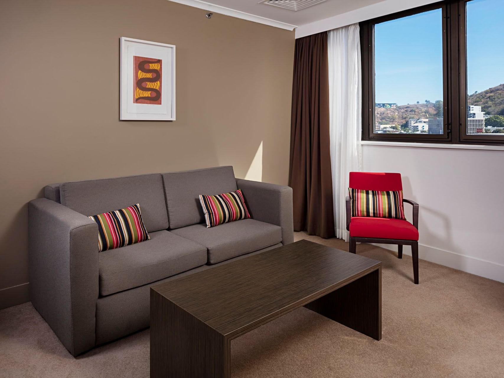 Lounge area with carpeted floors in One Bedroom Apartment at Grand Chancellor Townsville