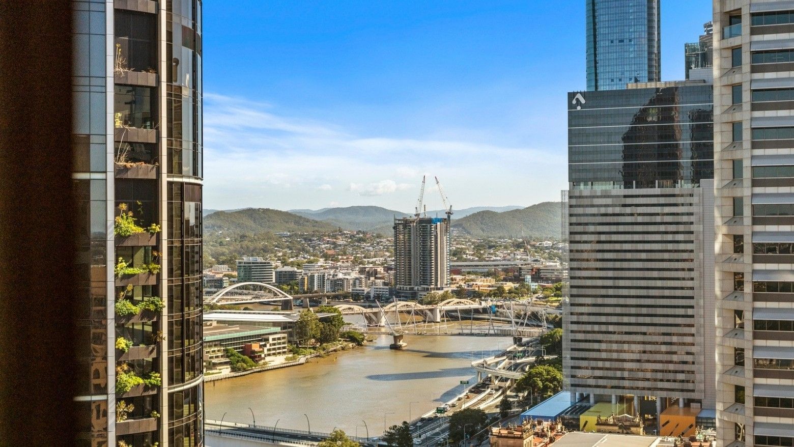 Elevated view of Brisbane River and cityscape with bridges and modern buildings at UniLodge Brisbane City.