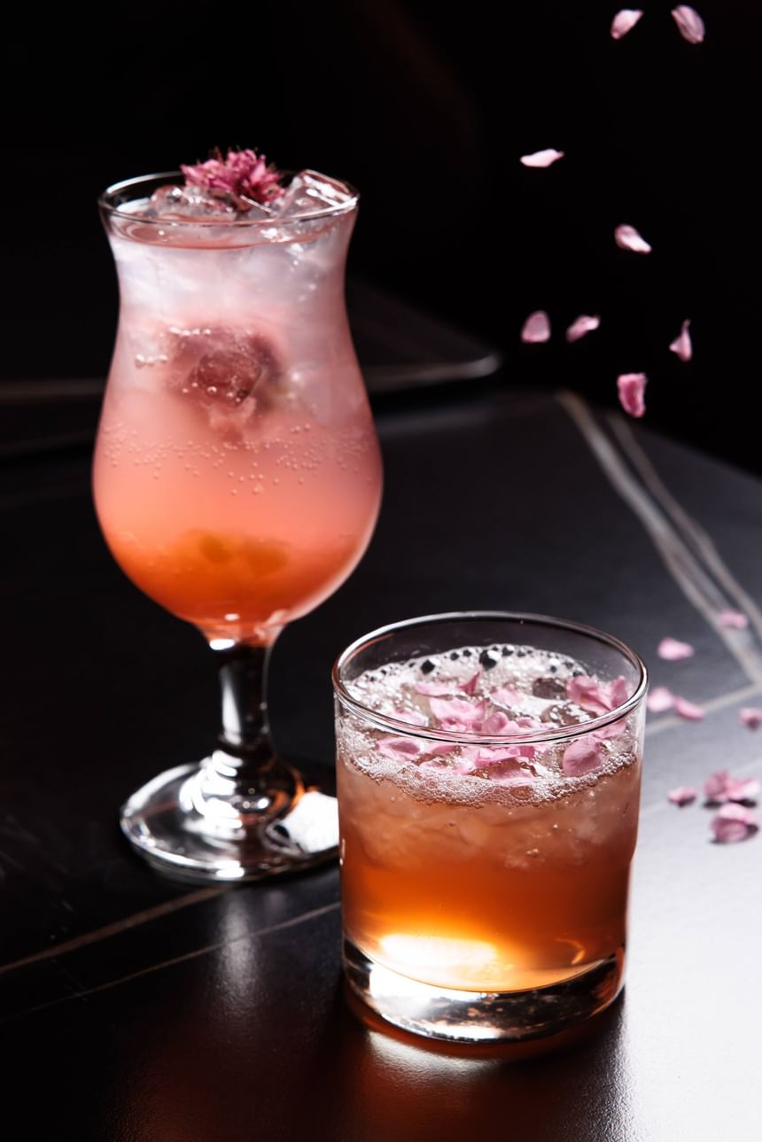 香港百樂酒店金盞吧的特色雞尾酒，兩杯粉紅色調飲品灑上花瓣點綴，擺放在吧枱上