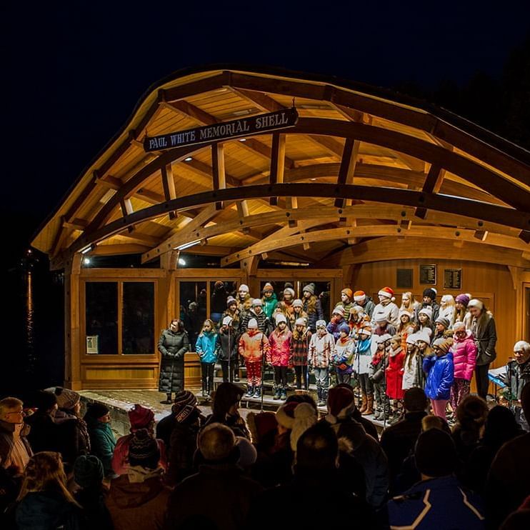 A group of people live singing on a stage at High Peaks Resort
