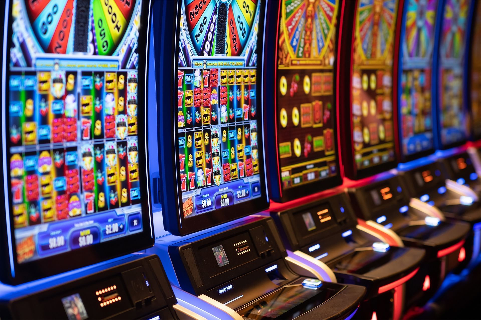 Colorful casino gaming machines lined side by side with illuminated screens and control panels at The Brook