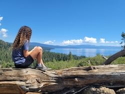 Girl on old tree by the Rim trail near Granlibakken Tahoe