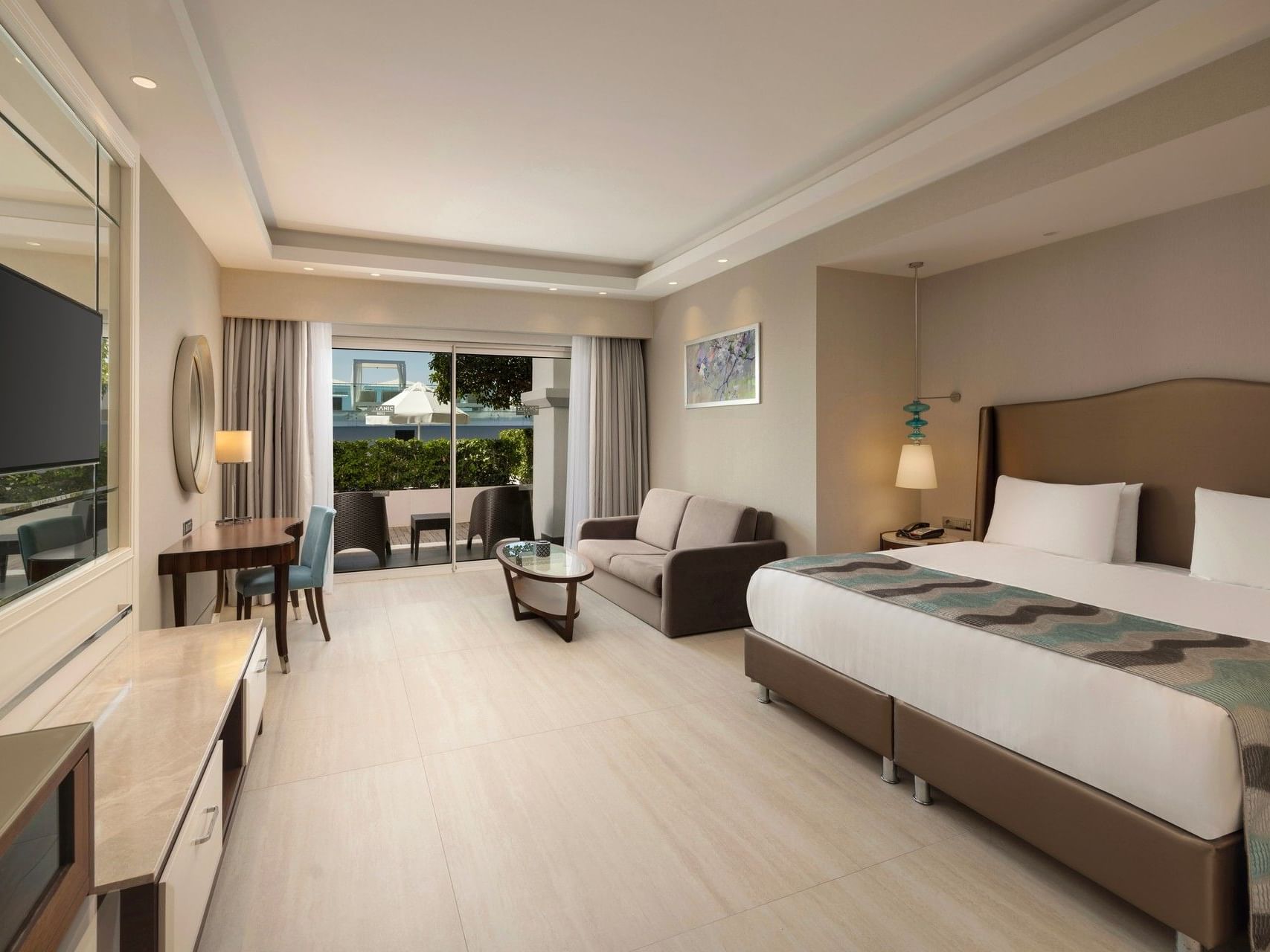 Spacious hotel room with twin beds, seating area, dining table, and terrace access at Titanic Deluxe Golf Belek
