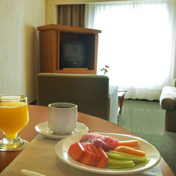 Fruit plate & drinks on table in Junior Suite at Fiesta Inn