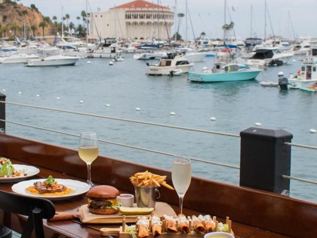 Food arranged on a wooden deck in Pier 24, Avalon Catalina restaurants at Hotel Atwater