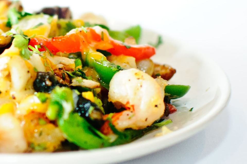 Colorful stir-fried shrimp with bell peppers, green beans, corn, and fresh herbs at Blackstone Mountain Lodge