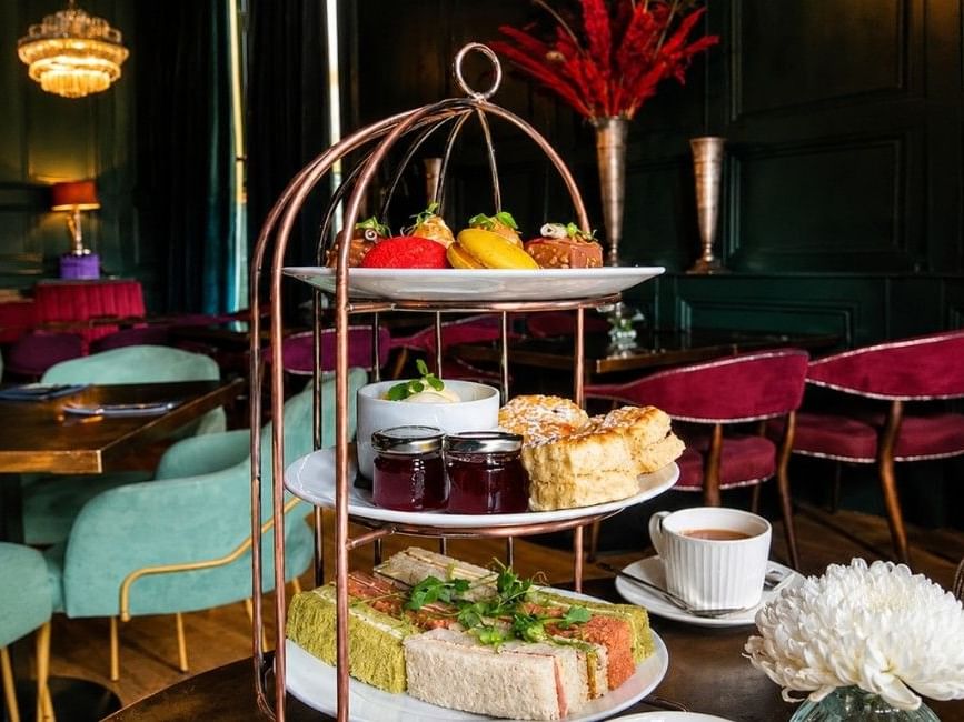 Elegant three-tiered afternoon tea stand with sandwiches, scones, jam and colourful pastries at Easthampstead Park Hotel