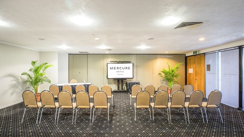 Tinaroo Room in theatre style chair setup and a display screen at Mercure Hotel Townsville