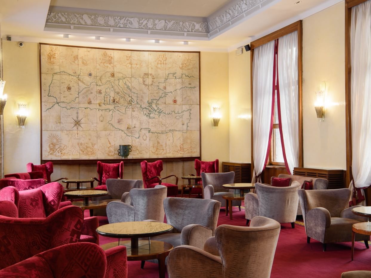 Hotel lounge with red chairs and red carpet at Bettoja Hotel Mediterraneo