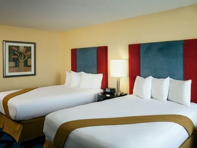 Comfy double bed in Cascade Double Queen room by Plaza Inn & Suites at Ashland Creek​