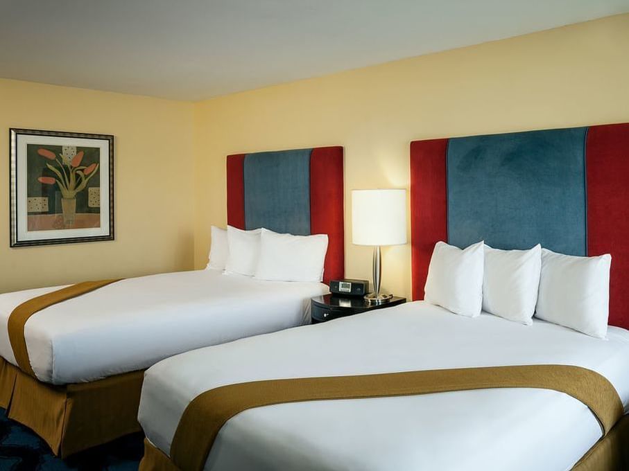 Comfy double bed in Cascade Double Queen room by Plaza Inn & Suites at Ashland Creek​