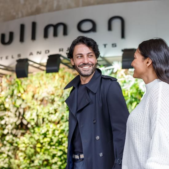 Couple holding hands and entering into Pullman Sydney Hyde Park