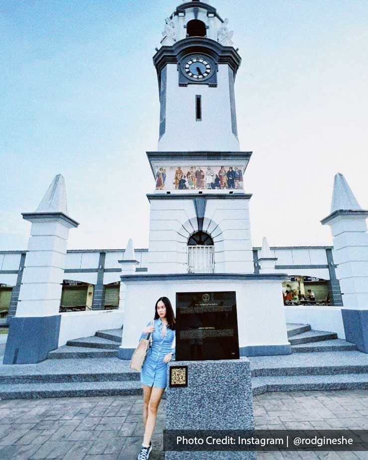 A lady was taking a picture in front of the Birch Memorial Clock Tower - Lexis Suites Penang