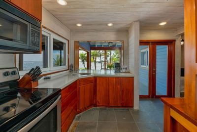 Kitchen area with wood cabinets in Grand Villa at Roatan, Honduras, accommodations Barefoot Cay Resort & Marina