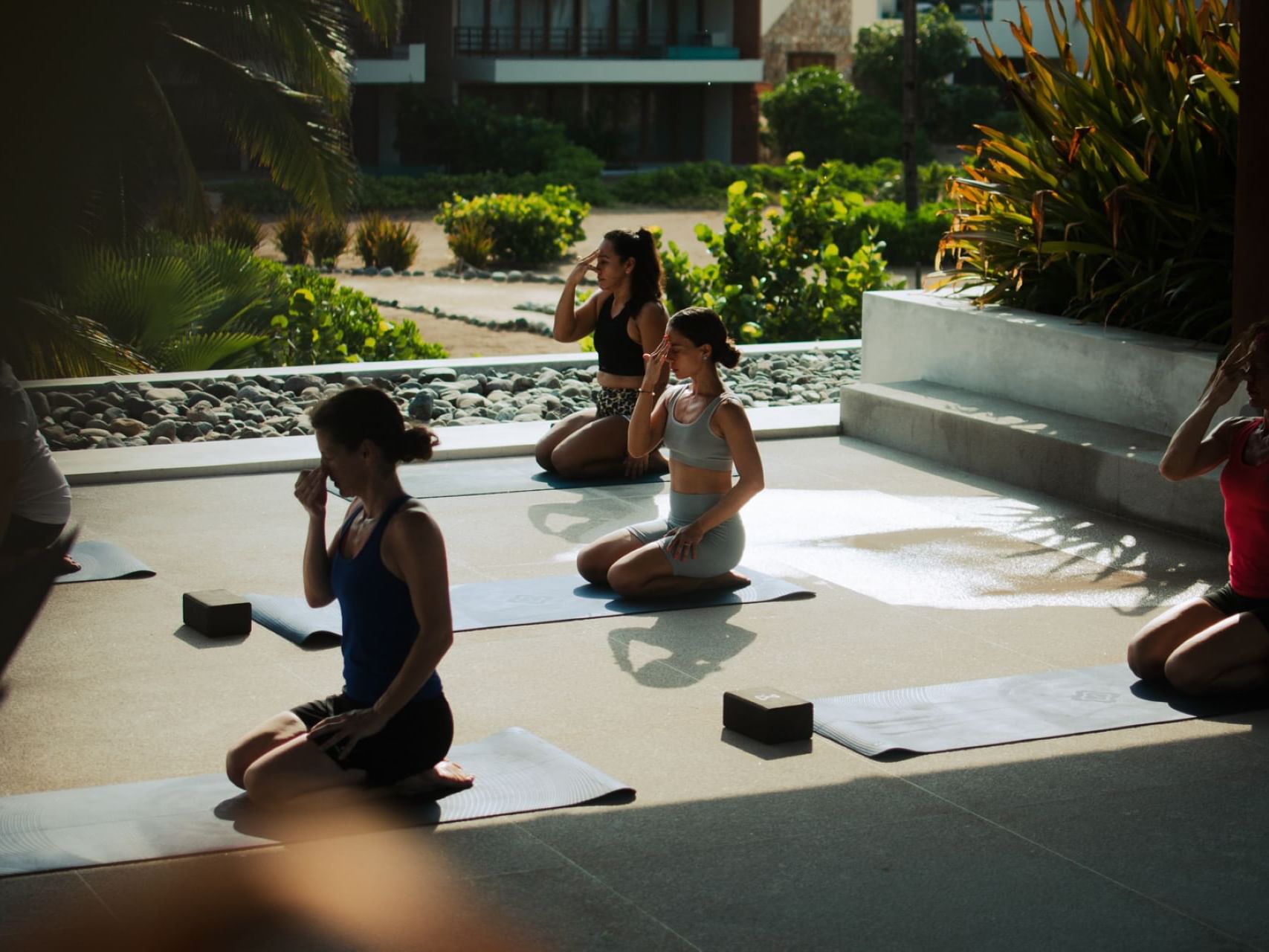 Women engage in yoga exercises at Marea Beachfront Villas