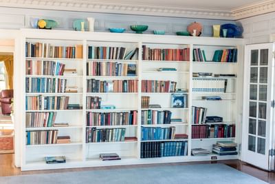 White wooden bookshelf filled with various books at Mt Ada