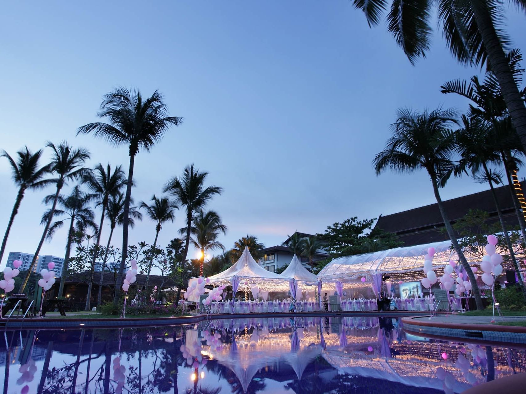 Exterior view of the Poolside Soiree arranged with white & lavender chairs for an event at Saujana Hotel Kuala Lumpur