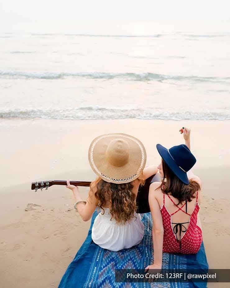 girls singing and playing guitar on the beach - Grand Lexis PD