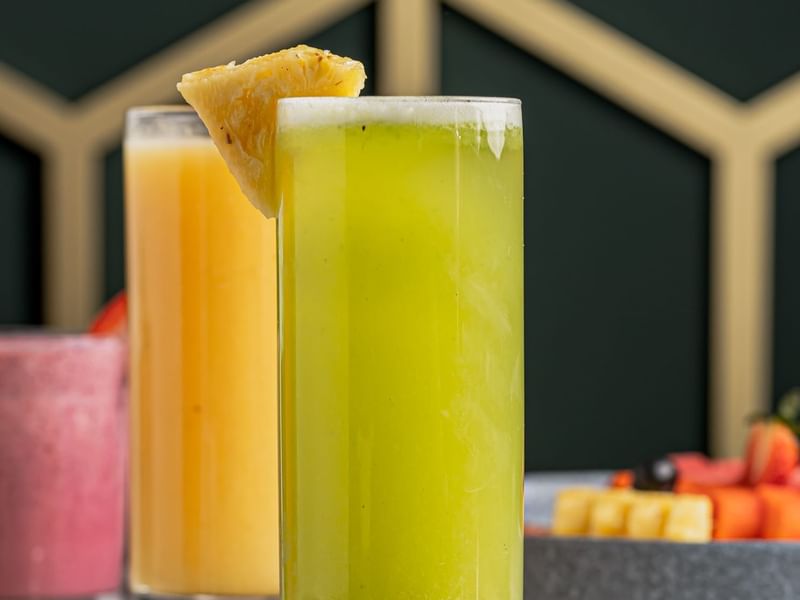 Tall glasses of juices, garnished with a pineapple wedge, at Los Canarios, Fiesta Americana Travelty