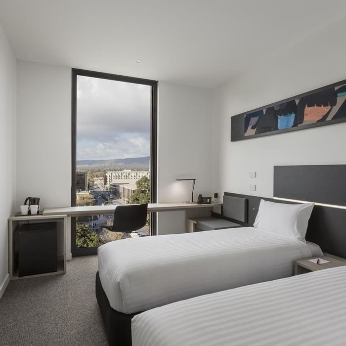 TV facing two beds and workspace by the window in Superior Room Two Single Beds City View at Ibis Adelaide
