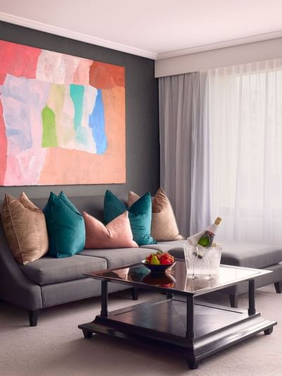 Living area with wall art and plush seating in Signature Suite at Sofitel Brisbane Central